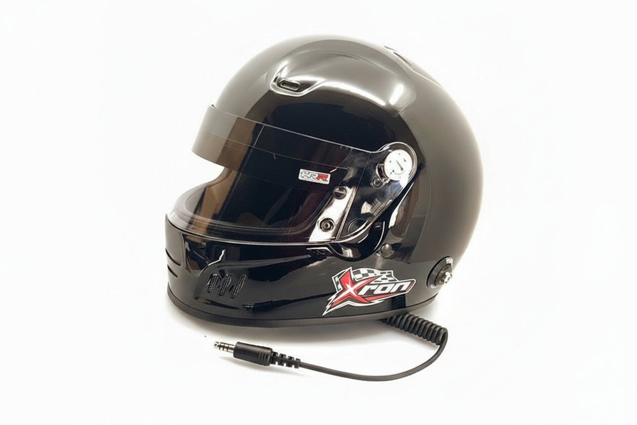 XRON SA2025 motorsport helmet gloss black with integrated communications coil cord — side view showing XRON logo and visor mechanism