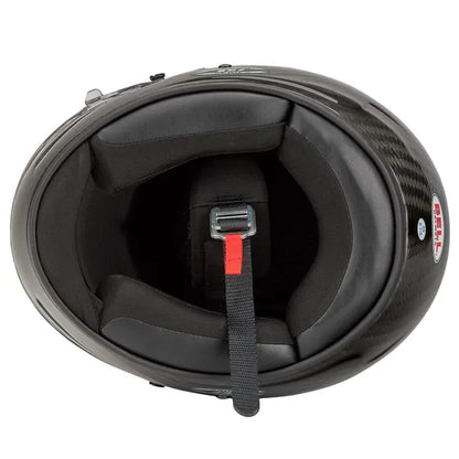 Black karting helmet with a red strap on a white background
