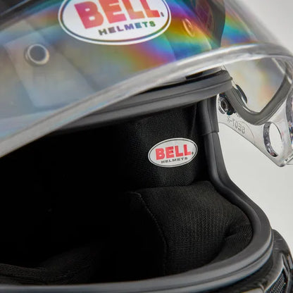 Close-up of a Bell helmet with rainbow visor and logo.