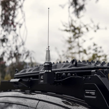 Rugged Radios POINT5 UHF CB antenna mounted on a bracket beside a vehicle roof rack