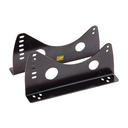 A pair of black steel OMP seat brackets with multiple mounting holes, designed for side mounting to vehicle frames.