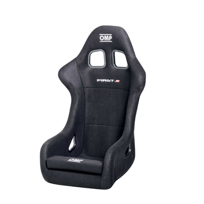Black OMP First R FIA 8855-1999 racing seat with a fiberglass shell and velour upholstery, featuring side windows and a removable base cushion.
